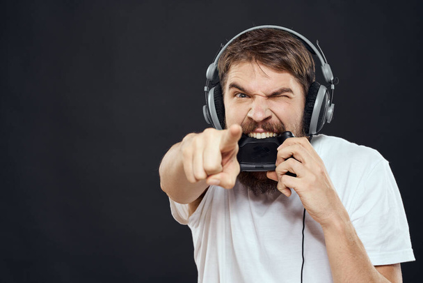 man in headphones with gamepad fun entertainment games lifestyle dark background - 写真・画像