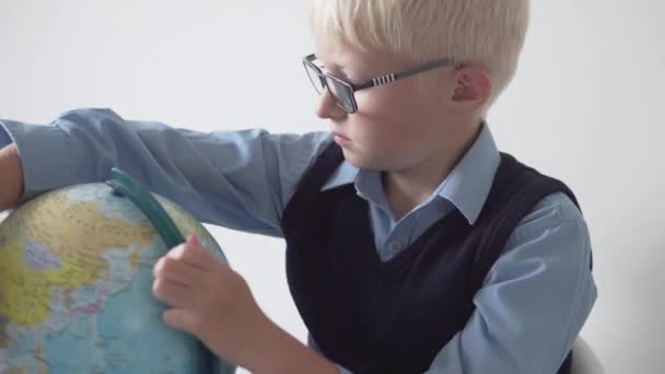 Poika koulupoika silmälasipäinen etsii maata Globe - Materiaali, video