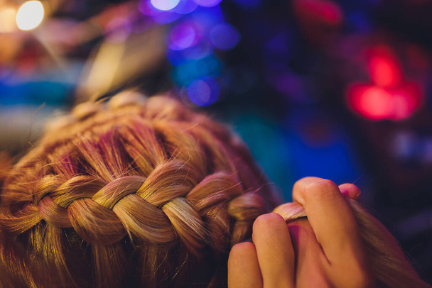 Process of braiding the master weaves braids on her head blond little girl in beauty salon close up. Professional hair care and creating hairstyles. - Foto, Imagem