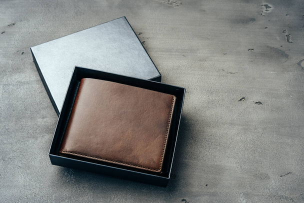 New brown leather wallet on dark background - Fotó, kép