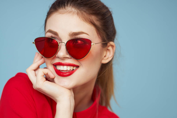 Lovely woman in dark glasses bright makeup red lips glamor blue background - Photo, Image