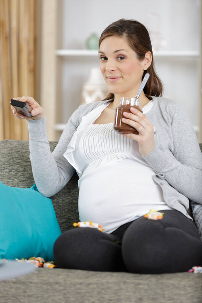 a pregnant woman eats chocolate - Foto, afbeelding