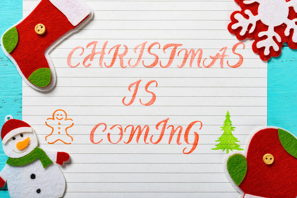 paper written with Christmas is coming and some decorations - Photo, Image