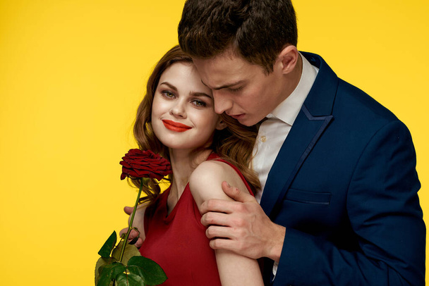 Couple in love man and woman with red rose classic costume red dress model - Foto, afbeelding