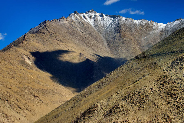Paysage rocheux avec ciel bleu et pics de glace, pierres brunes et rochers au col Changla, Leh, Ladakh, Jammu-et-Cachemire, Inde - Photo, image