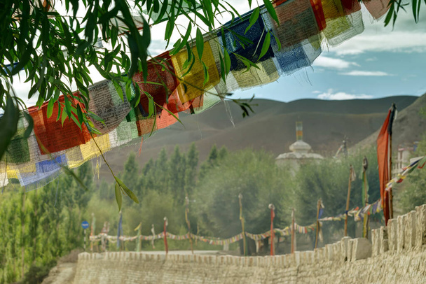 Banderas religiosas budistas, Juego de luces y sombras en las montañas de Mulbekh, montañas del Himalaya con sombra de nubes en el fondo, Ladakh, Jammu y Cachemira, India - Foto, imagen