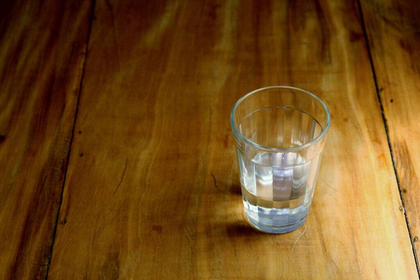 Вид полуполного стакана на деревянном фоне - Фото, изображение