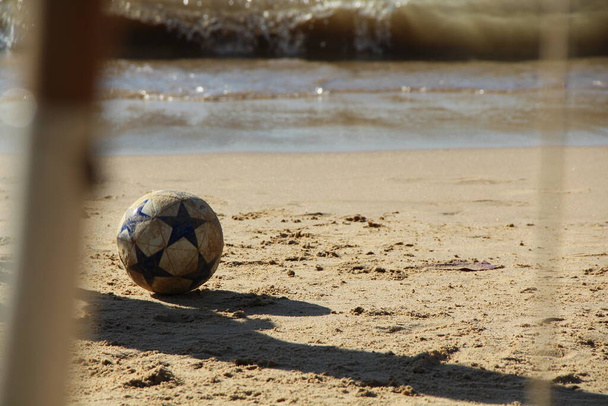 Blick auf die Beine der Menschen beim Fußballspielen am Sandstrand  - Foto, Bild