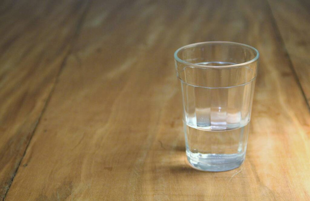 Vista de um copo meio cheio sobre fundo de madeira - Foto, Imagem