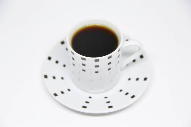 Vista de uma xícara de café cheia em um pires em fundo branco  - Foto, Imagem