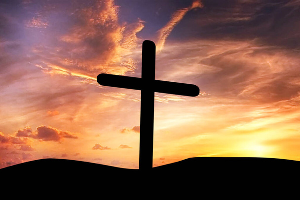 Cross silhouette with sunset background. Cross on the mountain at sunset. Beautiful cloudy sunset sky - Photo, Image