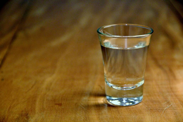 View of a shot of vodka on wooden background - Photo, Image
