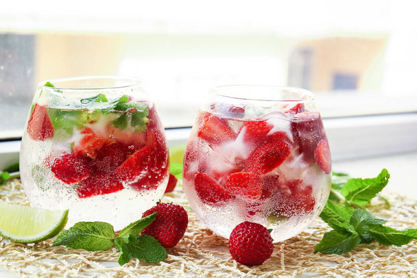 Glasses of fresh strawberry mojito on window sill - Photo, Image
