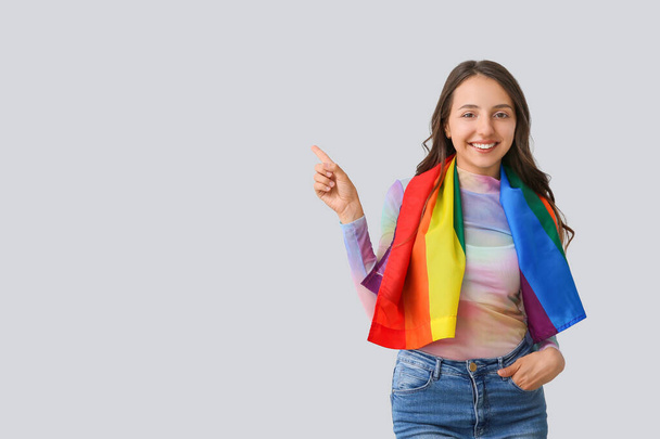 Giovane donna con bandiera LGBT su sfondo chiaro - Foto, immagini
