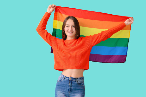Young woman with LGBT flag on color background - Foto, Imagem