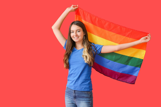 Giovane donna con bandiera LGBT su sfondo a colori - Foto, immagini