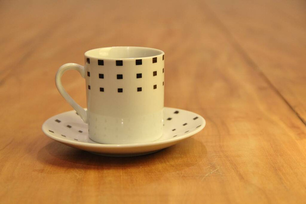 Vista de uma xícara de café vazia em um pires em fundo de madeira - Foto, Imagem
