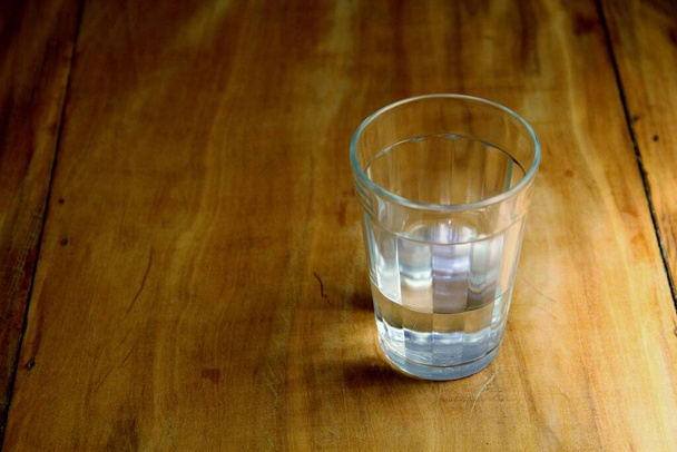 Вид полуполного стакана на деревянном фоне - Фото, изображение