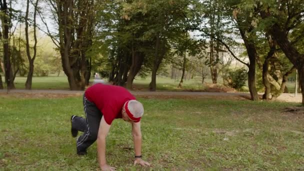 Attivo sportivo anziano 80 anni che fa esercizi di push-up. Allenamento cardio in parco per nonno - Filmati, video
