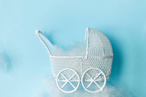 Желание стать матерью или отцом. Детская коляска игрушка на фоне блесток - Фото, изображение