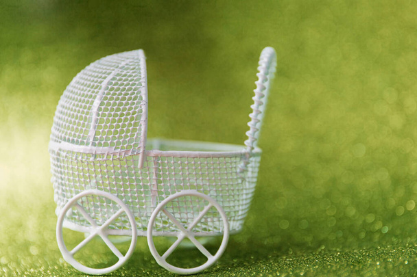 Wunsch, Mutter oder Vater zu werden. Kinderwagen-Spielzeug auf Glitzerhintergrund - Foto, Bild