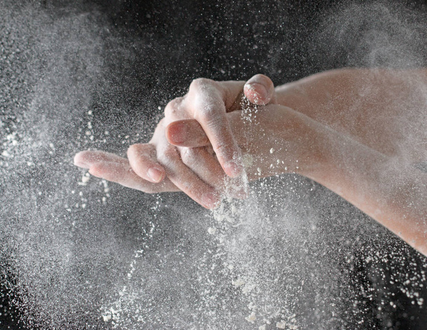 Hands in flour on black background - Photo, Image
