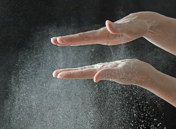 Kädet jauhoina mustalla pohjalla - Valokuva, kuva