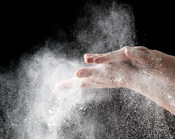 Flour hands on a black background - Foto, Imagen