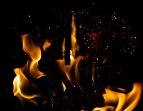 黒地に火花を散らし炎を放つ - 写真・画像
