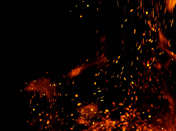 Siyah arkaplanda kıvılcımlar saçan ateş alevleri - Fotoğraf, Görsel
