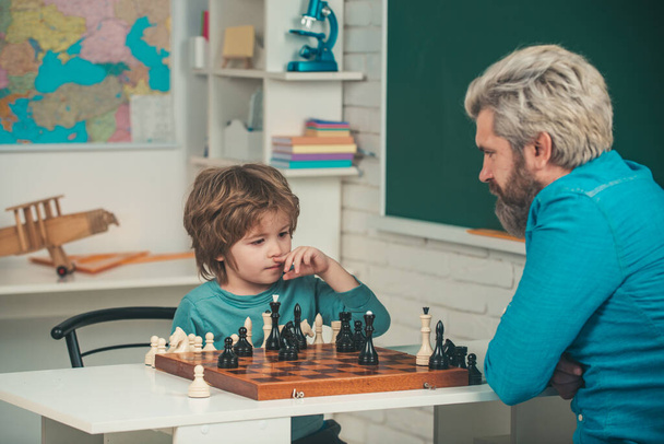 Teacher and kid. Games and activities for children. Teacher and child. Man teacher play chess with preschooler child. Father and son. - Foto, afbeelding