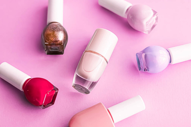 Nail polish bottles on pink background, beauty brand - Foto, afbeelding