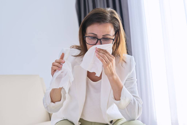 Woman sneezes in handkerchief, businesswoman got sick in the office - Zdjęcie, obraz