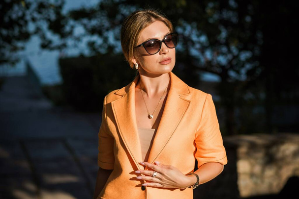 Femme à la mode dans une tranchée orange. Femme en manteau dans la rue, tenue de femme. Style fantaisie pour dames, couleurs d'automne et détails de mode  - Photo, image