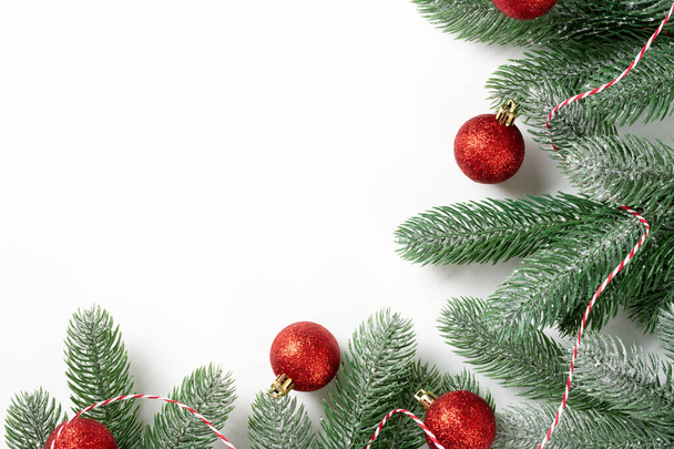 Christmas background. Red decorations on spruce branches on a white background. Christmas Flatly. Top view from copyspace - Foto, immagini
