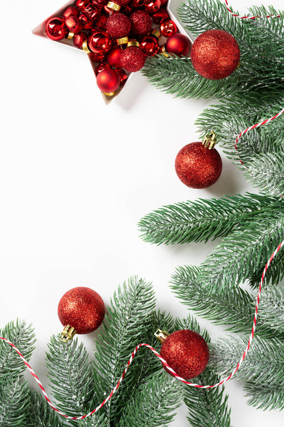 Christmas background. Red decorations on spruce branches on a white background. Christmas Flatly. Top view from copyspace - Foto, Imagem