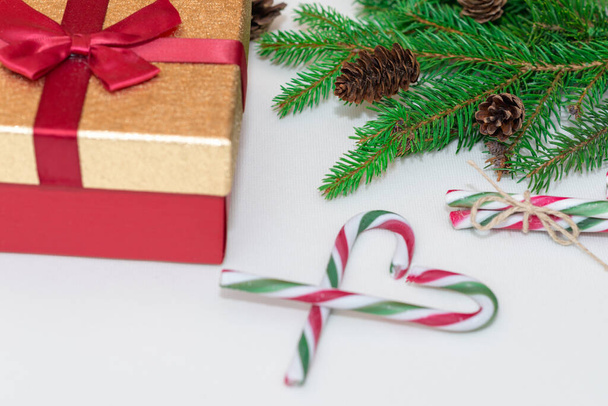 2021年のトップビュークリスマスのコンセプト、新年のコンセプト。ギフトボックス、キャンディースタッフ、心のクリスマスツリーの枝としてのキャンディーの杖、モミの木の枝 - 写真・画像