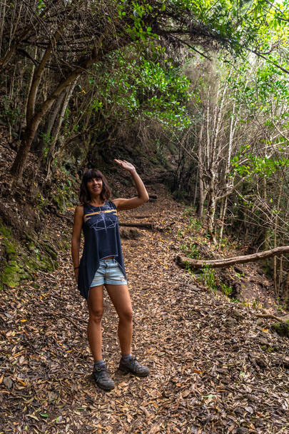 A young woman on the trekking trail of the Los Tinos natural park on the northeast coast on the island of La Palma, Canary Islands. Spain - Foto, imagen