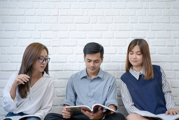 Eine Gruppe asiatischer Studenten macht Brainstorming und liest Bücher. - Foto, Bild