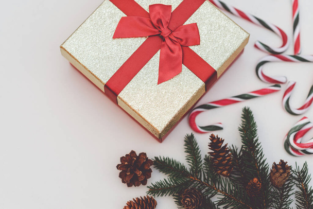 Χριστουγεννιάτικη ιδέα, Πρωτοχρονιά. Κουτί δώρων, ζαχαρωτά, ζαχαρωτά, κλαδιά χριστουγεννιάτικων δέντρων. Δέντρα Fir κλαδιά, κοντά. Τονωμένο.Λευκό φόντο. - Φωτογραφία, εικόνα