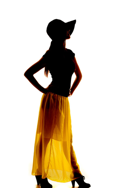silhouette woman see through skirt hands hips hat - Foto, Imagen