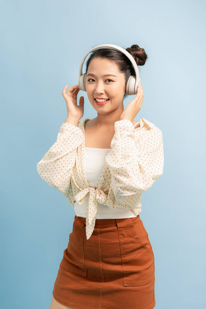 joyful asian woman wearing headphone and listening music from app in smartphone. - Photo, Image