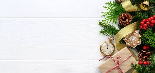 Fir tree branches with pocket watch, christmas decorations and gift box on white wooden background - Photo, image