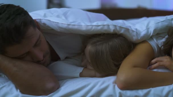 De ouders met een dochter die op het bed slaapt bij een kerstboom - Video