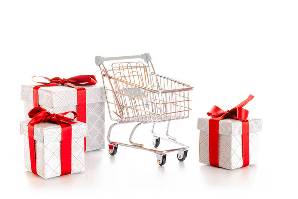 販売の背景。白い背景に隔離されたクリスマスや誕生日のギフトボックスとスーパーマーケットのためのトロリーカート。割引プロモーションとブラック・フライデーのコンセプト。テキストのコピースペース - 写真・画像