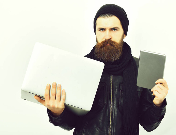 Bearded brutal caucasian hipster holding tablet and laptop - Zdjęcie, obraz