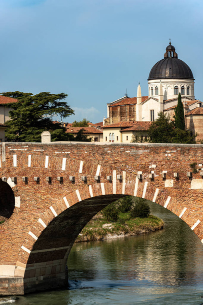 Βερόνα. Ponte Pietra (Πέτρινη γέφυρα), Ι αιώνας π.Χ. και η εκκλησία του Αγίου Γεωργίου στην Braida (XV-XVI αιώνα) σε αναγεννησιακό στυλ. Μνημείο παγκόσμιας κληρονομιάς της UNESCO, Βένετο, Ιταλία, Ευρώπη. - Φωτογραφία, εικόνα