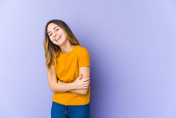 Young caucasian woman isolated on purple background laughing and having fun. - Foto, Imagem