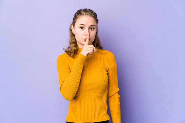 Young caucasian woman on purple background keeping a secret or asking for silence. - Photo, image