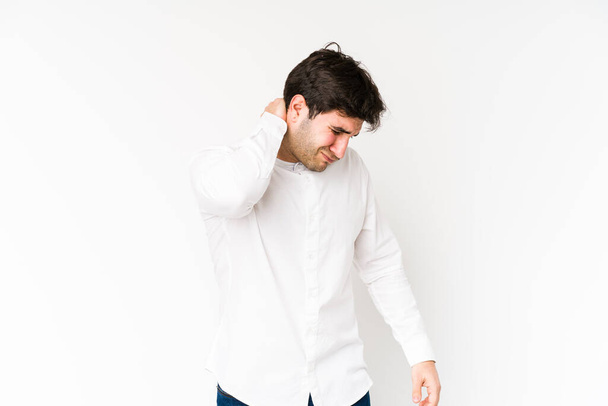 Young man isolated on white background having a neck pain due to stress, massaging and touching it with hand. - Photo, Image